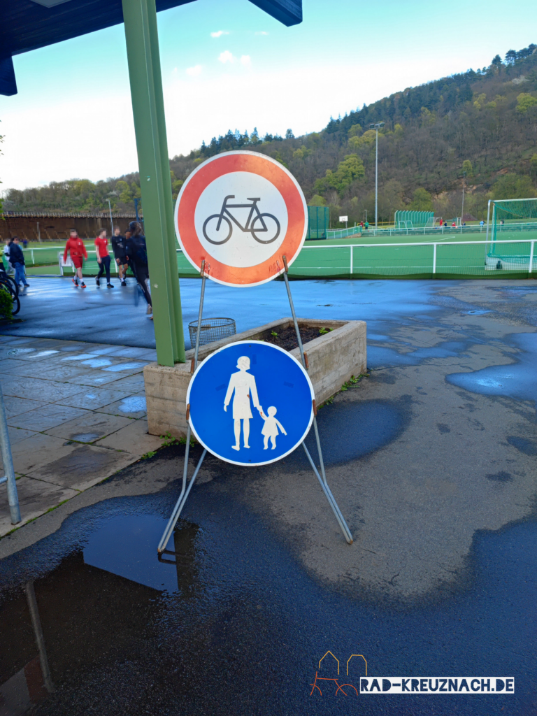 Eingang des Stadion Salinental mit Schildertafel: Oben Radfahren verboten, unten Gehweg